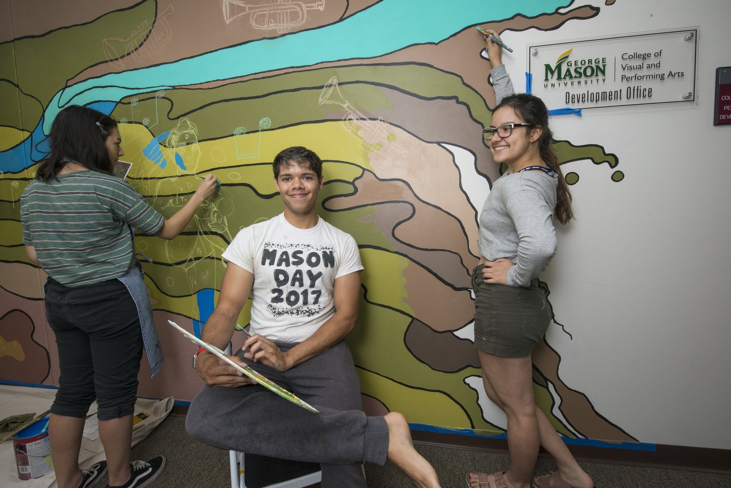 Students painting the mural in College Hall.