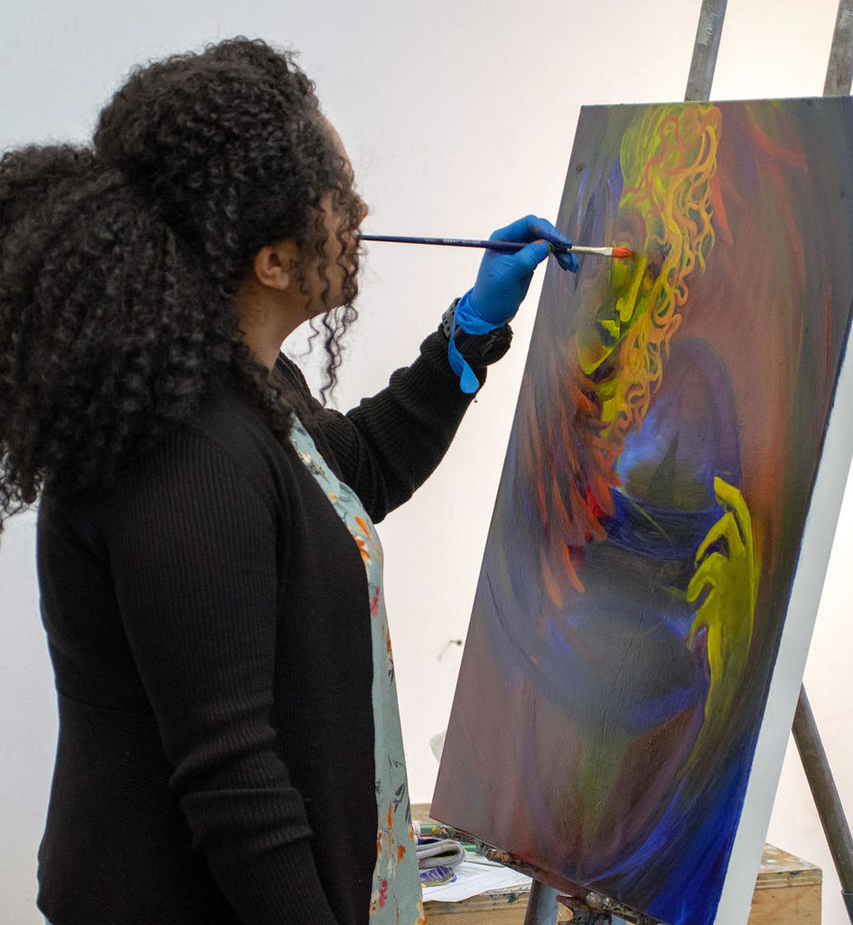 Mason student painting at a canvas