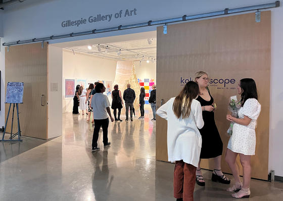 Visitors to the 2023 Senior Art Show enjoying some of the student exhibits.