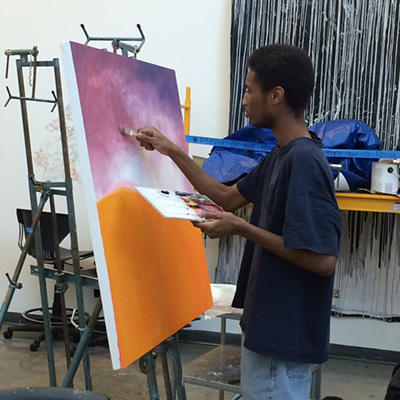 student painting at easel